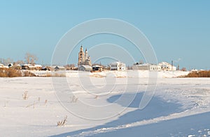 Wintry snowy village with a church in the distance