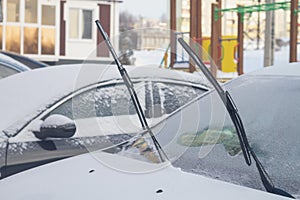 The wipers of the car are raised up so as not to freeze to the window glass in winter