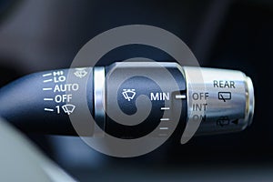 Wipers control. Modern car interior detail. Adjusting speed of screen wipers in car.