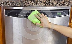 Wiping Clean Dishwasher with Microfiber rag photo