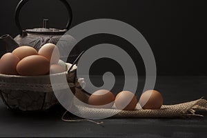 Wire basket with fresh eggs and teapot
