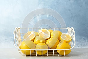 Wire basket with lemons on table