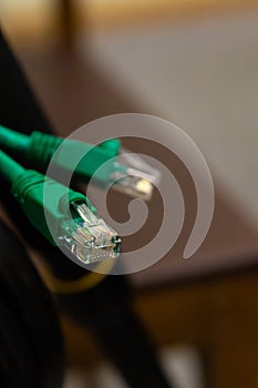 Wire contact rj45 plastic cable green connector on a blurry computer design background
