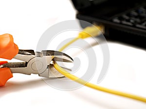 Wire cutter cutting network cable from laptop on white background