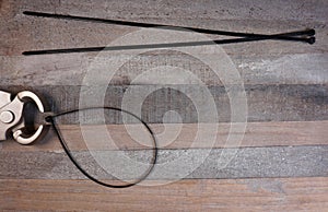 Wire Cutter for tyraps on wooden background with copy space for your text