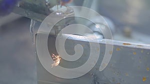 Wire cutting machine working with metal workpiece with sparks - slow motion