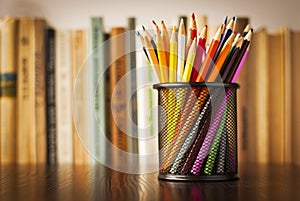 Wire desk tidy full of coloured pencils