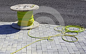 Wire electric cable with wooden coil of electric cable waiting to be slipped into the conduit