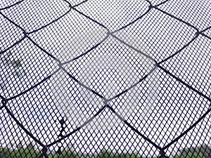Wire fence with blured background of landscape and sky