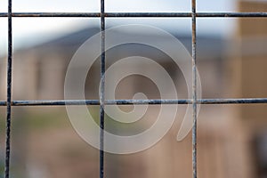 A wire fence with a selectively blurred background of a housing