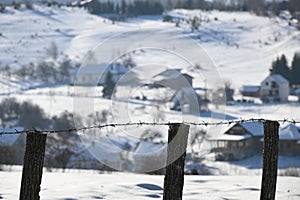 wire fence in the village during a snowy winter