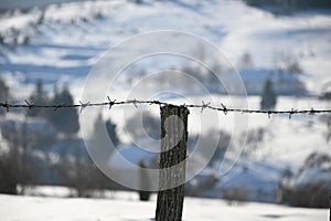 wire fence in the village during a snowy winter