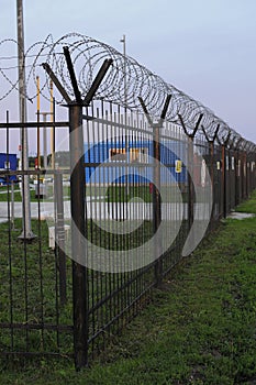 Wire mesh fence and a restricted area sign with blue sky background. Close-up photo, shallow depth of field, blured background