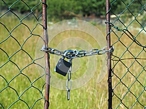 Wire netted fence locked by metail chain and padlocked