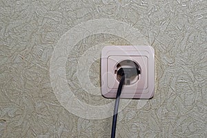 A wire with a plug from an electrical appliance is inserted into an outlet