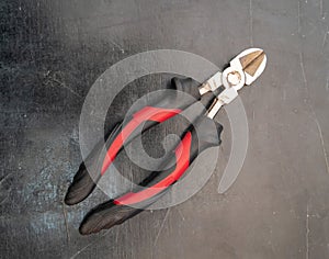 Wire stripper cutter isolated on black stone floor.