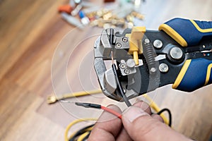 Wire strippers or cable strippers tool . Electrician holding cable strippers tool to remove insulation from electrical wires.Work photo