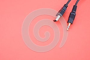 Wire with a USB end and audio cable on a red background