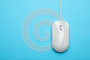 Wired computer mouse on light blue background. Space for text