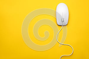 Wired computer mouse on yellow background. Space for text