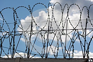 Wired fence with barbed wires on blue background