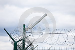 Wired fence with rolled barbed wires on white