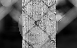 Wired fence shadow on pine wood pylon close up shot