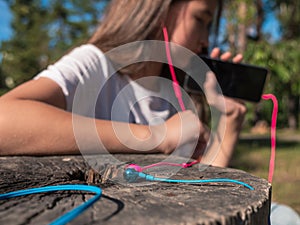 Wired pink and blue in-ear headset and girl listening to audio