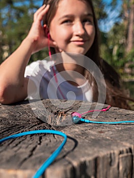 Wired pink and blue in-ear headset and girl listening to audio