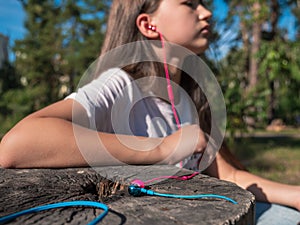 Wired pink and blue in-ear headset and girl listening to audio