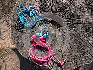 Wired pink and blue in-ear headset plugged in to the phone