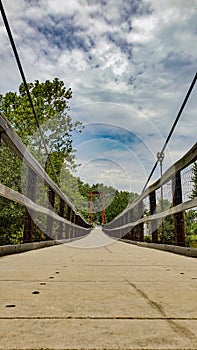 Wired walkway bridge with clouds in background