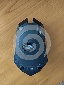 Wireless black gaming mouse on the table, back view