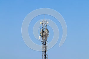 Wireless Communication Antenna Transmitter with antennas bright sunlight and sky background.