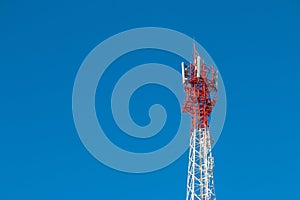 Wireless Communication Antenna Transmitter. Telecommunication tower with antennas on blue sky background.