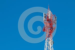 Wireless Communication Antenna Transmitter. Telecommunication tower with antennas on blue sky background.