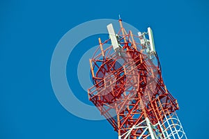 Wireless Communication Antenna Transmitter. Telecommunication tower with antennas on blue sky background.