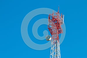 Wireless Communication Antenna Transmitter. Telecommunication tower with antennas on blue sky background.