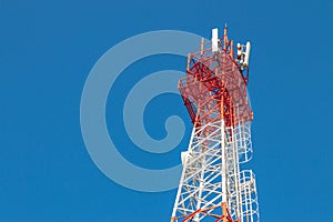 Wireless Communication Antenna Transmitter. Telecommunication tower with antennas on blue sky background.