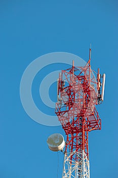 Wireless Communication Antenna Transmitter. Telecommunication tower with antennas on blue sky background.