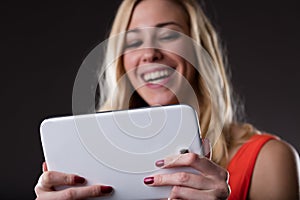 Wireless connected digital tablet held by a smiling blonde woman