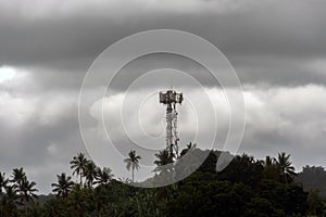 wireless data station against the background of a cloudy sky on a mountain in the jungle. Cell tower