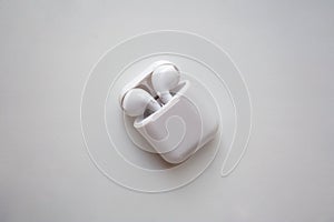 Wireless ear buds in glossy white plastic case