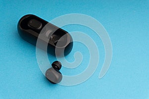 Wireless earbuds or earphones on blue background. Copy space