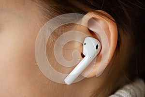 Wireless earphone in the girl`s ear