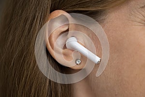 Wireless earphone object in female ear close up