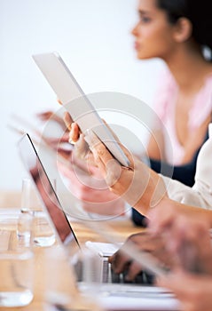 Wireless freedom in the boardroom. a group of businesspeople using their wireless devices during a meeting.