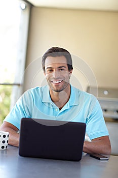 Wireless freedom at home. a handsome man using his laptop at home.