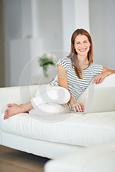 Wireless freedom. a young woman browsing the internet at home.