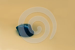 Wireless glossy black computer mouse on yellow background